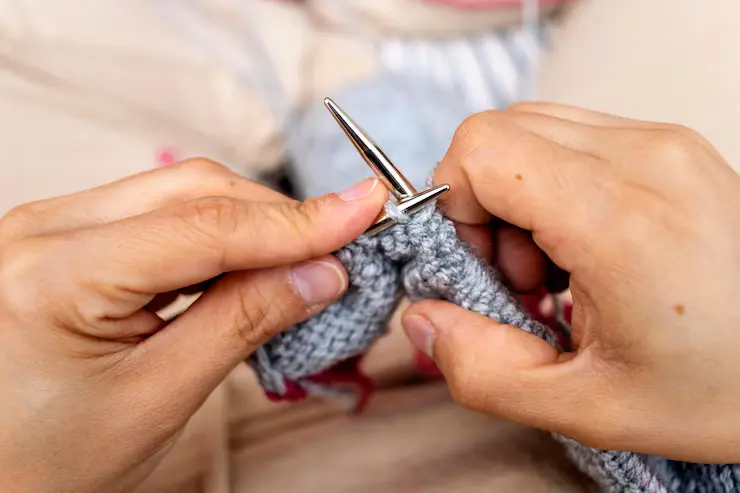 strikking ung kvinne hender som strikker med pinner